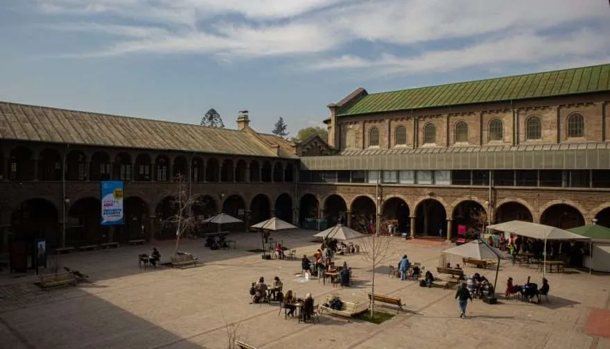 Fotografía de uno de los patios del Campus Oriente UC visto se ven mesas y personas