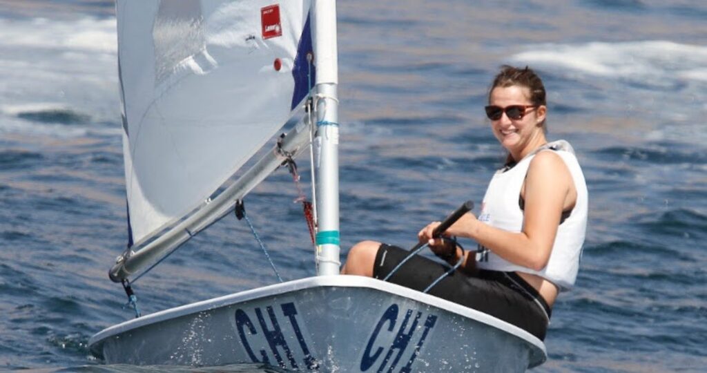 Fotografía de la Alumni UC, María José Poncell sonriendo mientras practica vela